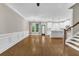 Open-concept living room featuring hardwood floors, large windows, wainscoting, and seamless access to the modern kitchen at 1547 Cambridge Pl, Marietta, GA 30062