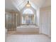 Bright bathroom features a jacuzzi tub, arched window, and glass shower at 1900 Briergate Dr, Duluth, GA 30097