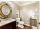 Charming powder room with granite countertop, decorative mirror, and rustic-style storage cabinet at 280 Selkirk Ln, Johns Creek, GA 30097