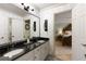 Elegant bathroom with a double vanity sink, dark countertop, and stylish leaf-patterned wallpaper at 280 Selkirk Ln, Johns Creek, GA 30097