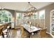Elegant dining room boasts natural light from large windows and a unique light fixture over a wooden table at 280 Selkirk Ln, Johns Creek, GA 30097
