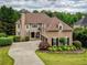 Charming home with manicured lawn, mature trees, and a long circular driveway at 280 Selkirk Ln, Johns Creek, GA 30097