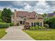 Well-manicured lawn and elegant home with a circular driveway and professional landscaping at 280 Selkirk Ln, Johns Creek, GA 30097