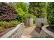 Garden path with stone walls, a wooden gate, and lush greenery at 280 Selkirk Ln, Johns Creek, GA 30097