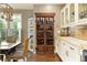 Beautiful kitchen showcasing a built-in wine cabinet, white cabinets, and granite countertops at 280 Selkirk Ln, Johns Creek, GA 30097