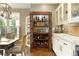 Kitchen featuring a wine cabinet with open doors to reveal shelved storage, and white cabinets at 280 Selkirk Ln, Johns Creek, GA 30097