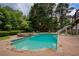 Backyard with a sparkling swimming pool, adjacent hot tub, and mature trees at 280 Selkirk Ln, Johns Creek, GA 30097