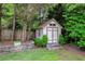 Backyard shed with charming details, surrounded by lush greenery and landscaping at 280 Selkirk Ln, Johns Creek, GA 30097
