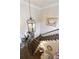 Foyer featuring staircase with wood treads, an ornate chandelier, and sitting area below at 280 Selkirk Ln, Johns Creek, GA 30097