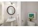 Stylish half bathroom with a pedestal sink, decorative mirror, and modern fixtures at 3331 Vintage Se Cir, Smyrna, GA 30080