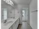 Bathroom with double sinks, a large mirror, and white cabinets with a view to the outside at 6125 Langdon Way, Cumming, GA 30028