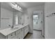 Bathroom with double sinks, a large mirror, and white cabinets with a view to the outside at 6125 Langdon Way, Cumming, GA 30028