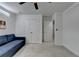 Bedroom with a blue sofa, white walls, ceiling fan, and two white doors to closet at 6125 Langdon Way, Cumming, GA 30028