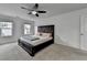 Bedroom featuring neutral carpet, white walls, two windows, and a dark-stained wood bed frame at 6125 Langdon Way, Cumming, GA 30028