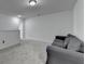 Bright bonus room features plush carpet, neutral walls, and comfortable gray couch at 6125 Langdon Way, Cumming, GA 30028