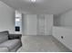 Bright bonus room with neutral walls, plush carpet, and comfortable gray couch at 6125 Langdon Way, Cumming, GA 30028