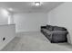 Inviting bonus room with plush carpet, neutral walls, and comfortable gray couch at 6125 Langdon Way, Cumming, GA 30028