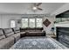 Comfortable living area showcases a fireplace, ceiling fan, large windows, and a sectional sofa at 6125 Langdon Way, Cumming, GA 30028