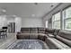 Open concept living room featuring a large sectional sofa and natural light from the windows at 6125 Langdon Way, Cumming, GA 30028