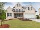 Charming brick home features a manicured lawn, black window shutters, and attached garage at 1077 Sweet Mia Ln, Powder Springs, GA 30127