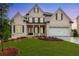 Charming brick home features a manicured lawn, black window shutters, and attached garage at 1077 Sweet Mia Ln, Powder Springs, GA 30127