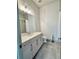 Well-lit bathroom with modern vanity, gray tile flooring, and a large mirror at 1153 Reynolds Square Ln # 16, Atlanta, GA 30307
