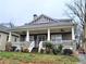 Charming home with a large covered front porch, white railings and stone pillar bases at 2132 Memorial Se Dr, Atlanta, GA 30317