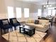 Bright living room featuring a comfortable beige sofa, stylish blue armchairs, and hardwood floors at 2132 Memorial Se Dr, Atlanta, GA 30317