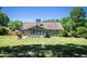 Spacious backyard with lush green lawn, a covered patio, and mature trees, ideal for outdoor activities and entertaining at 3335 Ivy Lake Dr, Buford, GA 30519