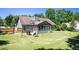Green backyard showcases mature trees, partial fencing, and a covered patio area with a basketball hoop, great for recreation at 3335 Ivy Lake Dr, Buford, GA 30519