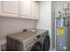 Laundry room with modern washer, dryer, cabinets, and water heater at 3335 Ivy Lake Dr, Buford, GA 30519