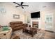 Cozy living room with a brick fireplace, comfortable leather sofa, and natural light streaming through the windows at 3335 Ivy Lake Dr, Buford, GA 30519