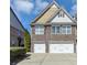 Charming townhome featuring stone accents, a symmetrical facade, and attached two-car garages at 805 Pleasant Hill Nw Rd # 343, Lilburn, GA 30047