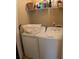 Functional laundry room with washer, dryer, and overhead shelving for storage at 805 Pleasant Hill Nw Rd # 343, Lilburn, GA 30047