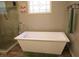Luxurious bathroom featuring a standalone tub, walk-in shower, and a decorative window at , Loganville, GA 30052