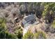 Aerial view of home and surrounding acreage, featuring mature trees and long driveway at 3133 Callie Still Rd, Lawrenceville, GA 30045