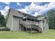 Rear exterior featuring a wooden deck with stair access and a spacious yard at 3133 Callie Still Rd, Lawrenceville, GA 30045