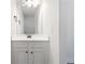 Clean bathroom with white cabinets, a single sink, and a large mirror at 3823 Dragon Fly Ln, Loganville, GA 30052