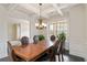 Elegant dining room featuring coffered ceilings, a chandelier, and a view to the front yard at 3823 Dragon Fly Ln, Loganville, GA 30052