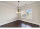 Inviting dining room featuring a chandelier, ample natural light, and dark hardwood flooring at 3823 Dragon Fly Ln, Loganville, GA 30052
