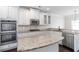 Bright kitchen featuring granite countertops, stainless appliances, and white cabinetry at 3823 Dragon Fly Ln, Loganville, GA 30052