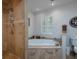 Bathroom featuring a soaking tub and stone-tiled shower at 517 Sheritan Sw Way, Smyrna, GA 30082
