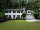Charming two-story home with white siding, black shutters, red door, well-manicured lawn, and an attached two-car garage at 517 Sheritan Sw Way, Smyrna, GA 30082