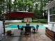 Backyard features an in-ground pool with outdoor seating and red umbrella at 517 Sheritan Sw Way, Smyrna, GA 30082