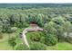 Estate aerial view featuring the home, a meadow, and a surrounding lush green forest at 2452 Camp Mitchell Rd, Grayson, GA 30017