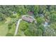 Aerial view of a tree-surrounded home featuring a circular drive, pool, outbuildings, and ample parking at 2452 Camp Mitchell Rd, Grayson, GA 30017