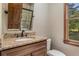 Bathroom featuring a granite countertop, wooden cabinets, and a window to the outside at 2452 Camp Mitchell Rd, Grayson, GA 30017