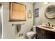 Classic bathroom featuring a toilet, sink with dark cabinet, and a framed round mirror at 2452 Camp Mitchell Rd, Grayson, GA 30017