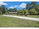 Charming single-story home with a well-manicured lawn and a long driveway, nestled amongst mature trees at 2452 Camp Mitchell Rd, Grayson, GA 30017