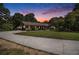 Charming single-story home with lush lawn and a long drive surrounded by mature trees at dusk at 2452 Camp Mitchell Rd, Grayson, GA 30017